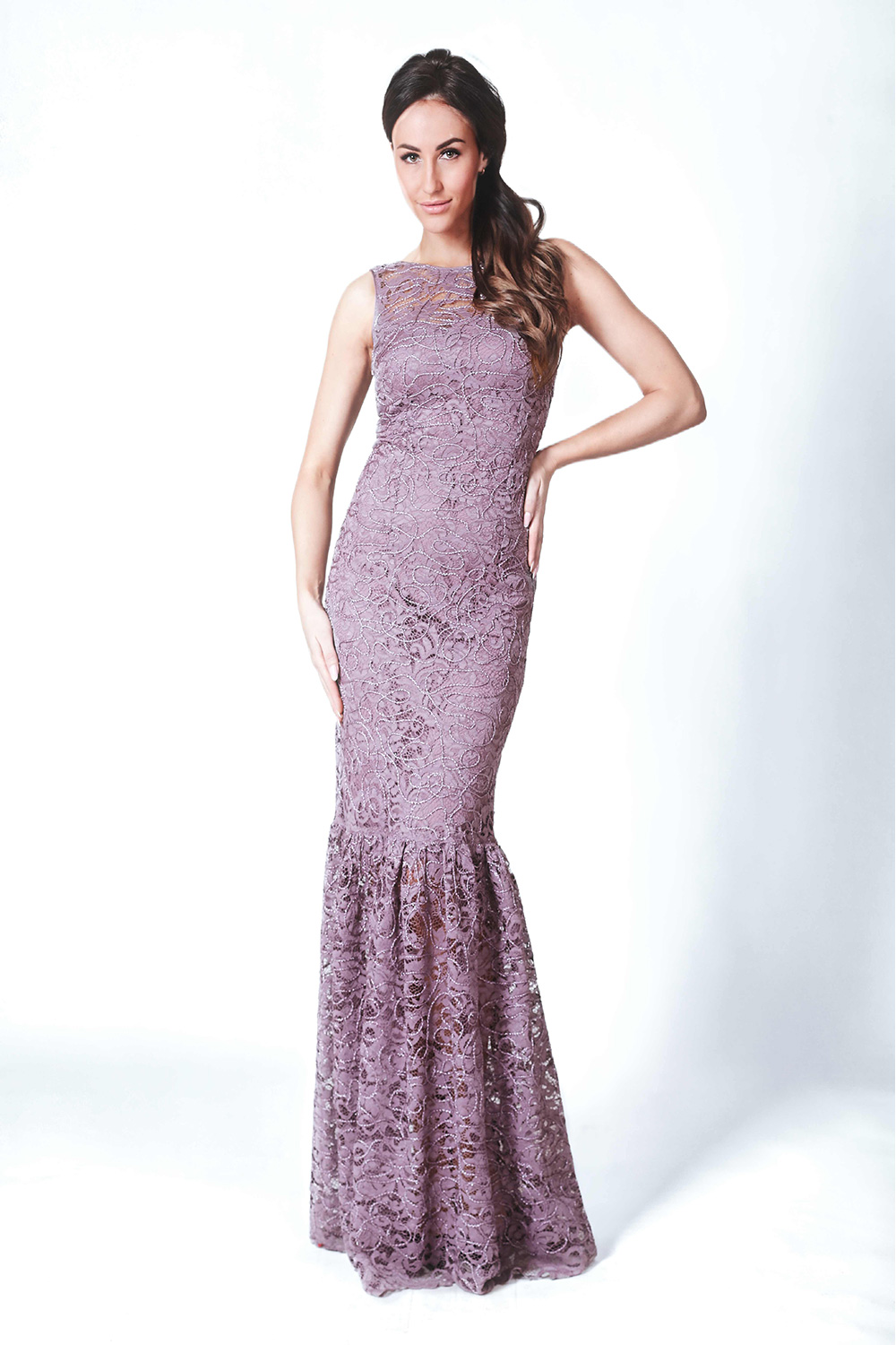 Woman in elegant purple lace gown posing.