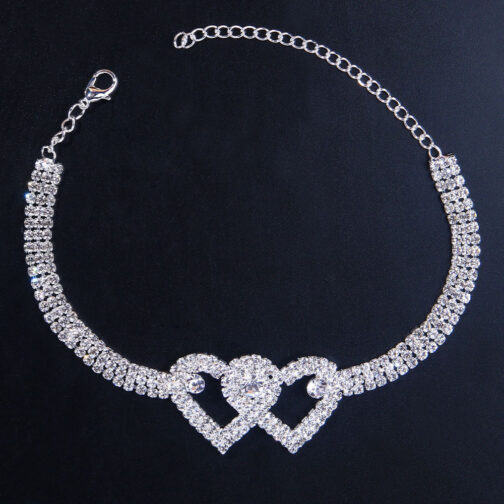 Sparkling heart-shaped diamond bracelet on black background.