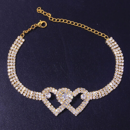 Gold heart-shaped bracelet with diamonds on blue background.