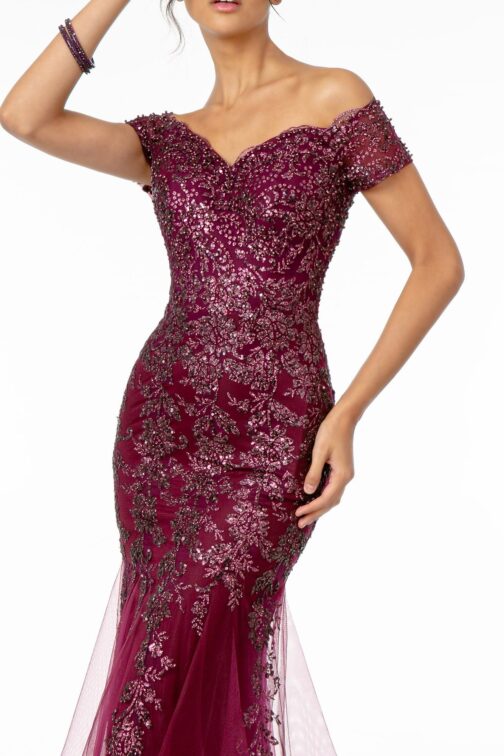 Woman in embellished burgundy evening gown.