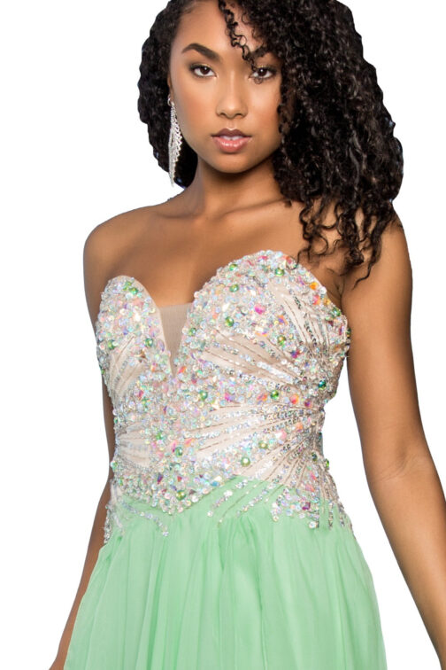 Woman in bejeweled green dress with curly hair