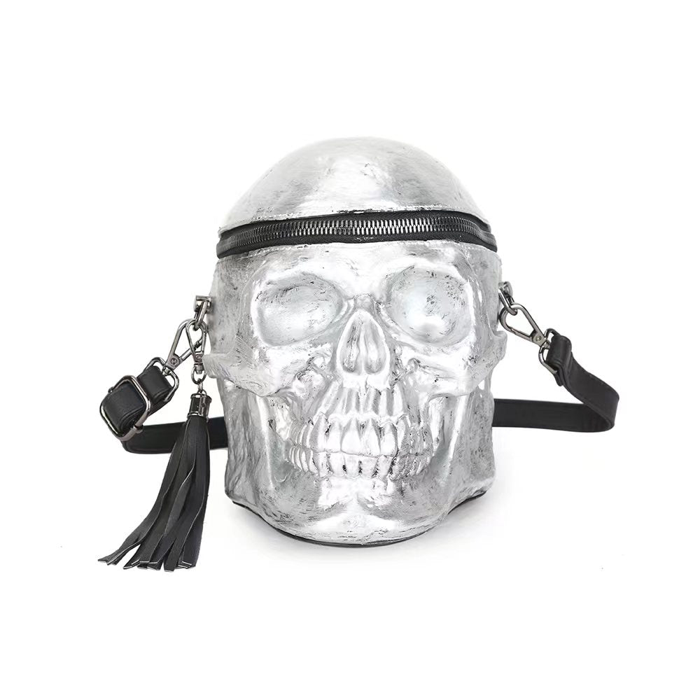 Silver skull-shaped purse with zipper and strap.